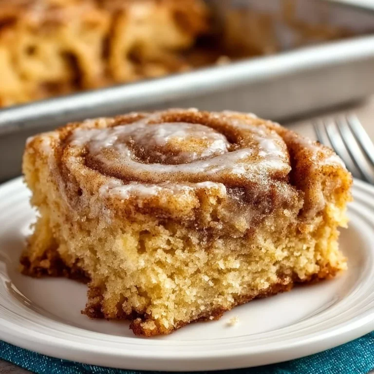 A delightful slice of homemade cinnamon roll cake with frosting on top
